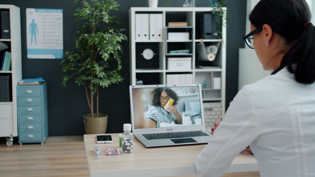 Crafting Captivating Headlines: Your awesome post title goes here Healthcare professional having virtual appointment with patient on laptop.